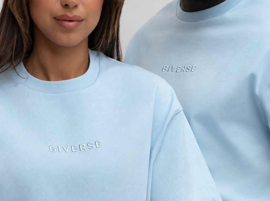 Close-up of two models wearing blue BIVERSE tops with embroidered chest logos.